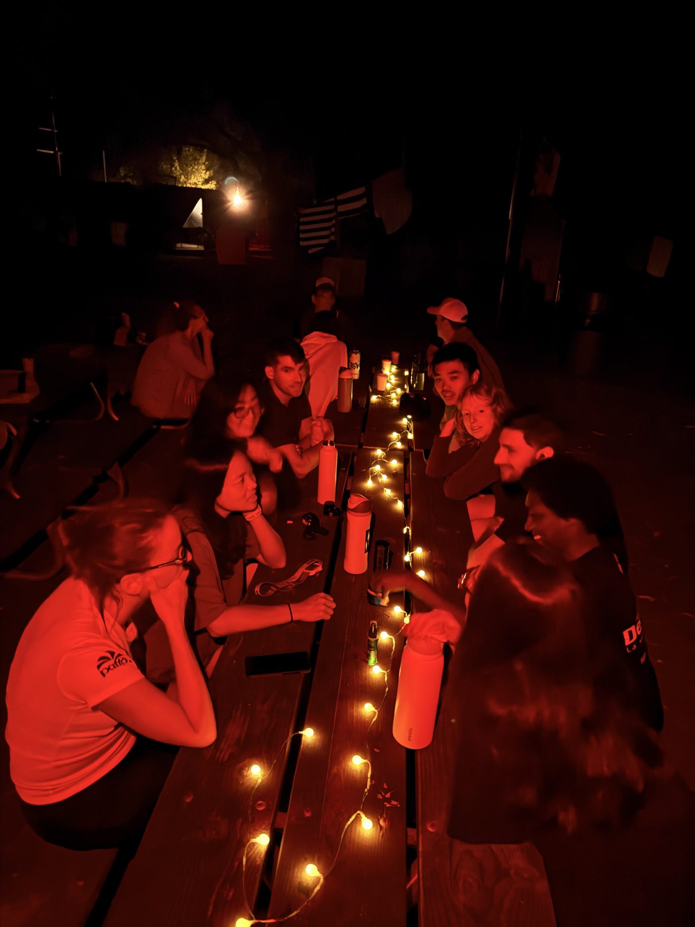 The group gathered around a string-lit picnic table one night at camp, deep in conversation